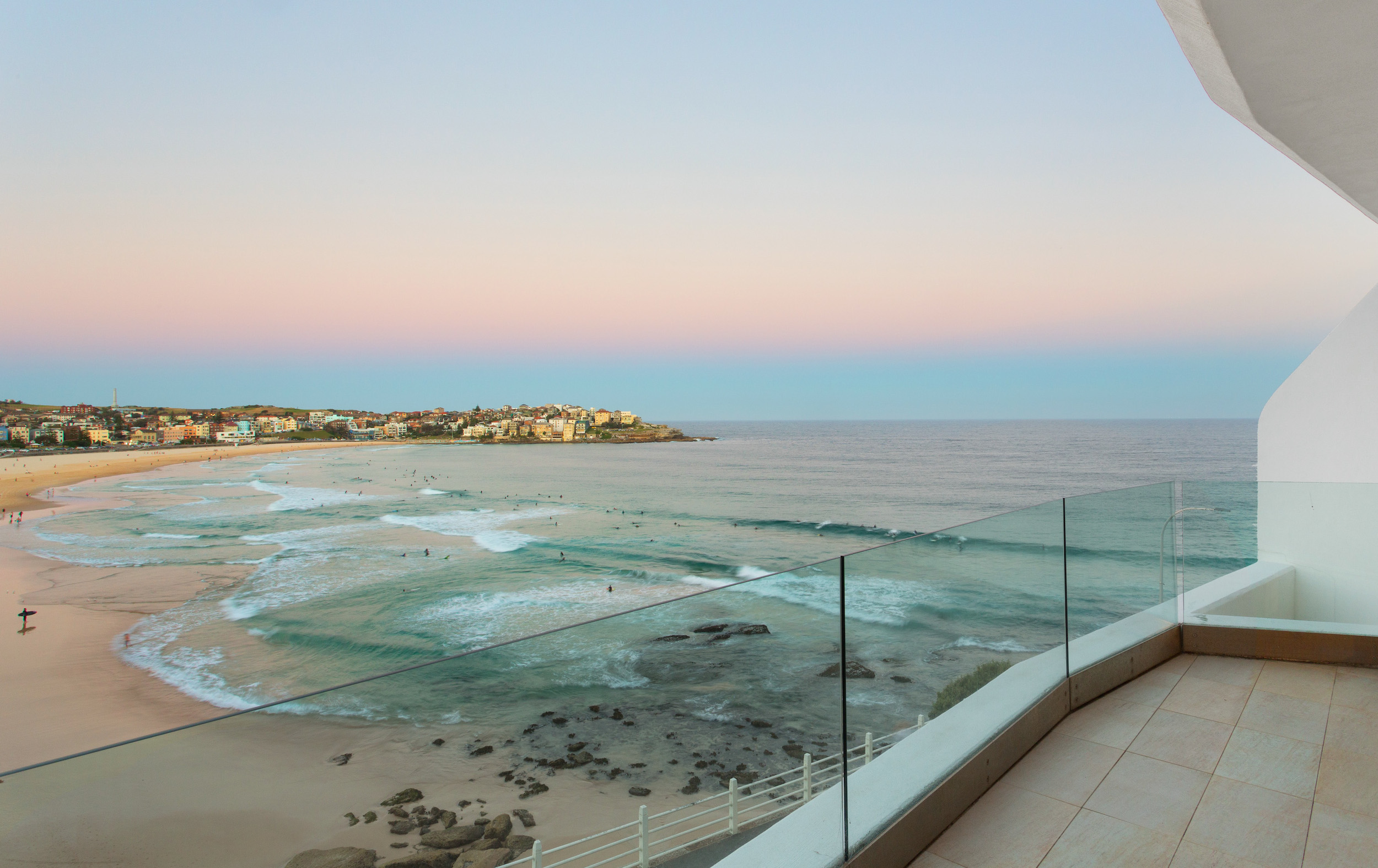 View of Bondi Beach at sunset taken from above with an orange-blue hazy sky