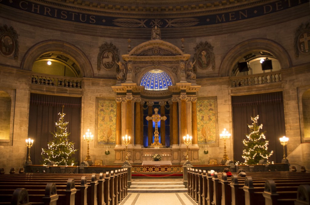 The central nave and beautiful blue-domed altar with lit-up Christmas trees on either side in Frederik’s Church, Copenhagen, Denmark