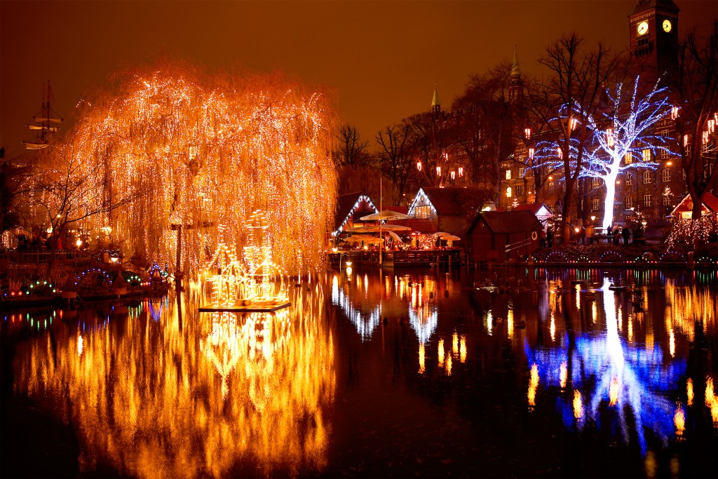 The lighted up trees and buildings of Tivoli Amusement Park reflecting into the lake, Sweden