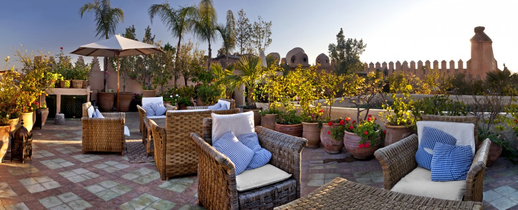 Seating areas and and potted plants on the rooftop terraces of Dar Les Cigognes, Marrakesh, Morocco