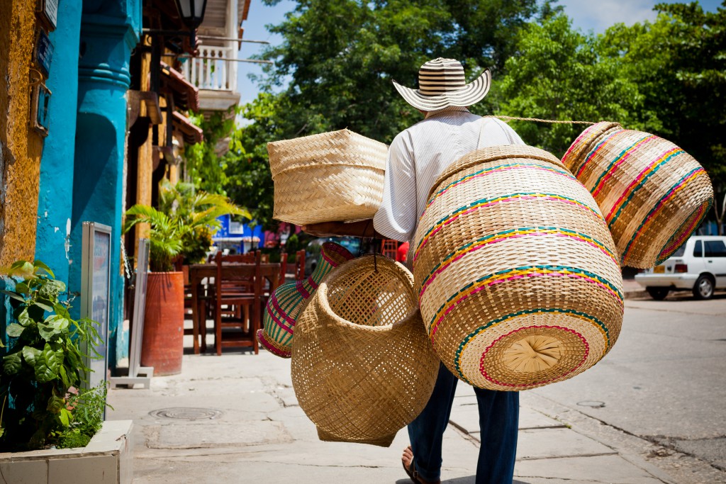 A basket vendor strolls the streets within the walled city of Cartagena, Colombia in the sweltering South American heat.