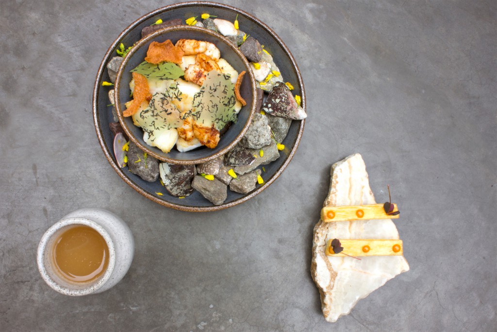 A meal is presented in a dish surrounded with a decoration of stones and flowers that provide context to the food’s origin at Central Restaurant, Lima, Peru