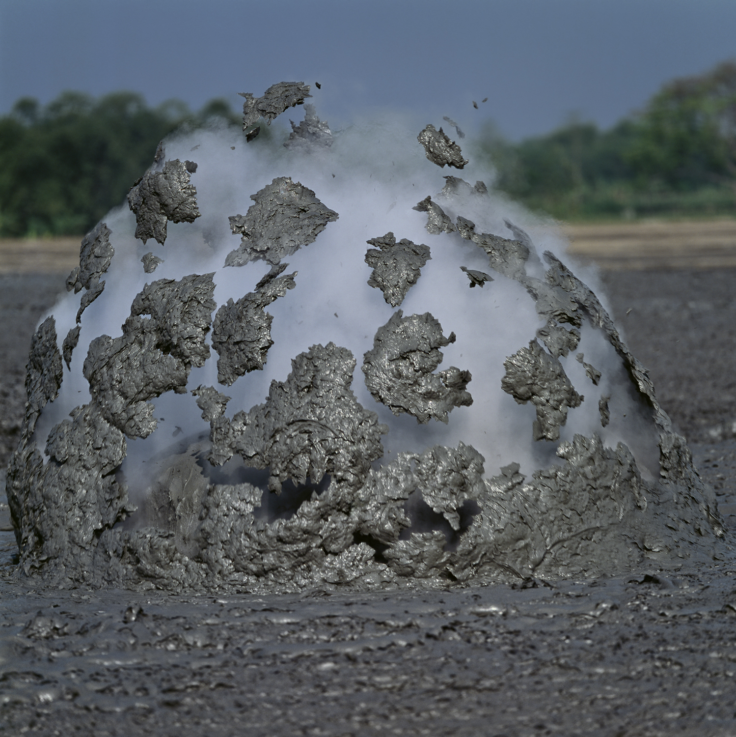 Blobs of mud in mid air from a bursting bubble, Bledug Kuwu, Indonesia 
