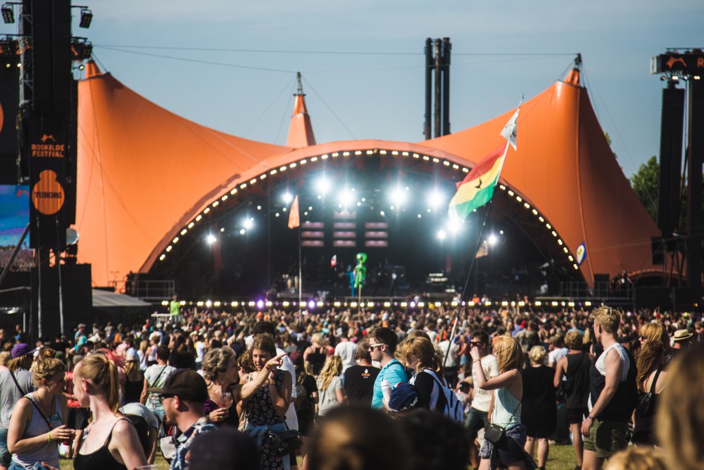 Orange tented stage with crowd in front of it