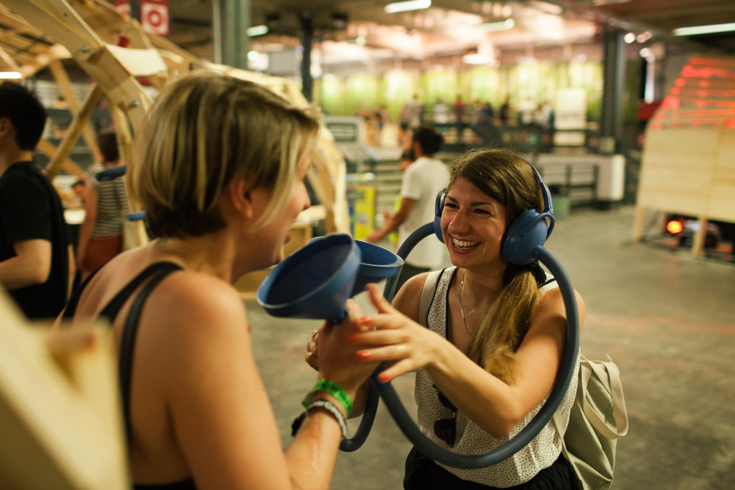 Two girls trying out a hearing contraption involving headphones, funnels and tubes