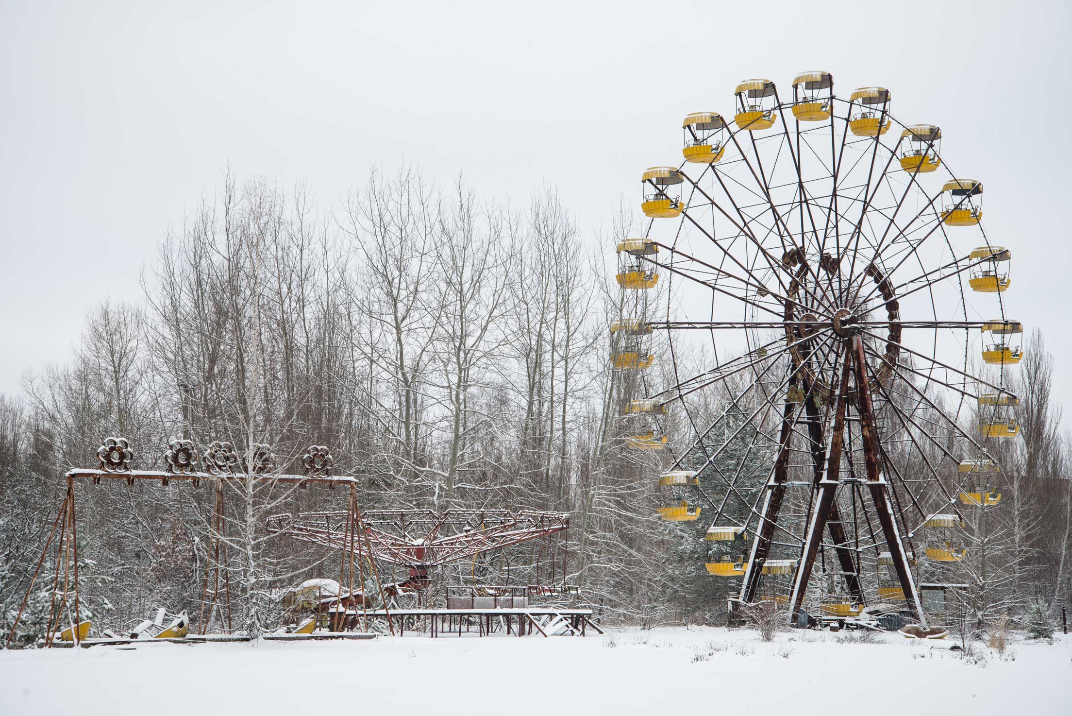 Abandoned park and ferris wheel in a snowy landscape and bare trees in Chernobyl, Russia