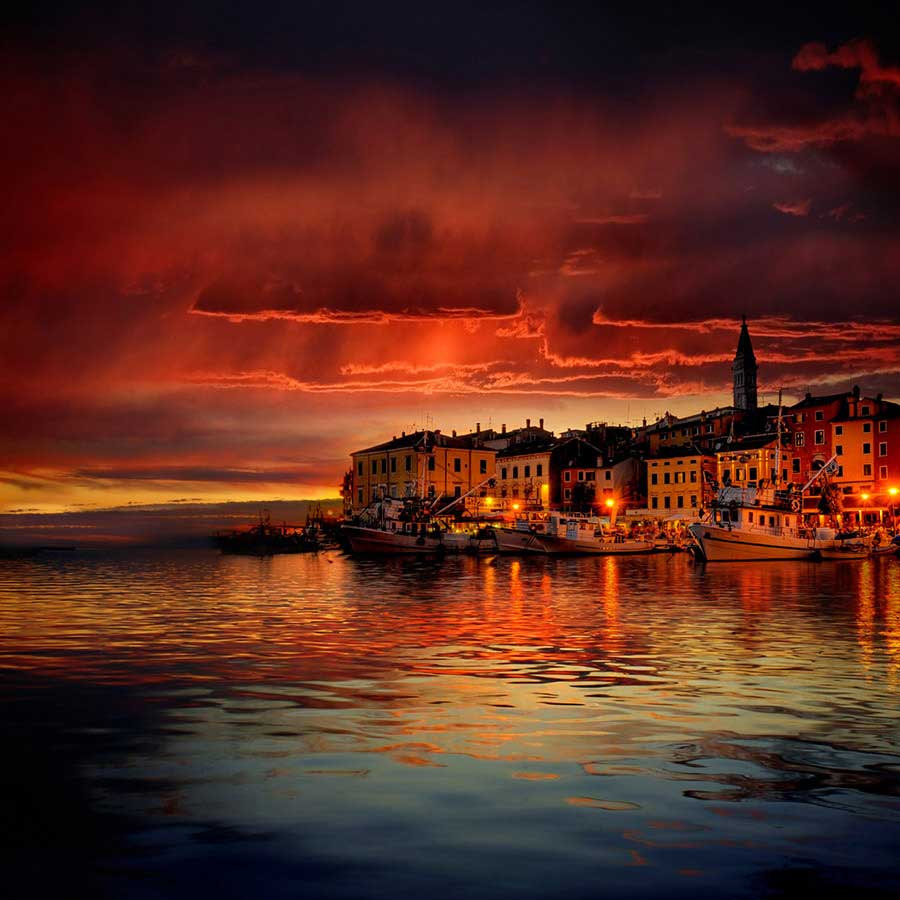 Rovinj city from the sea in a very orange sunset, one of many romantic destinations in Croatia