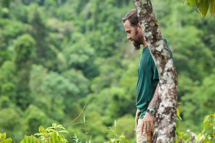 Man standing behind a tree in the Costa Rican jungle