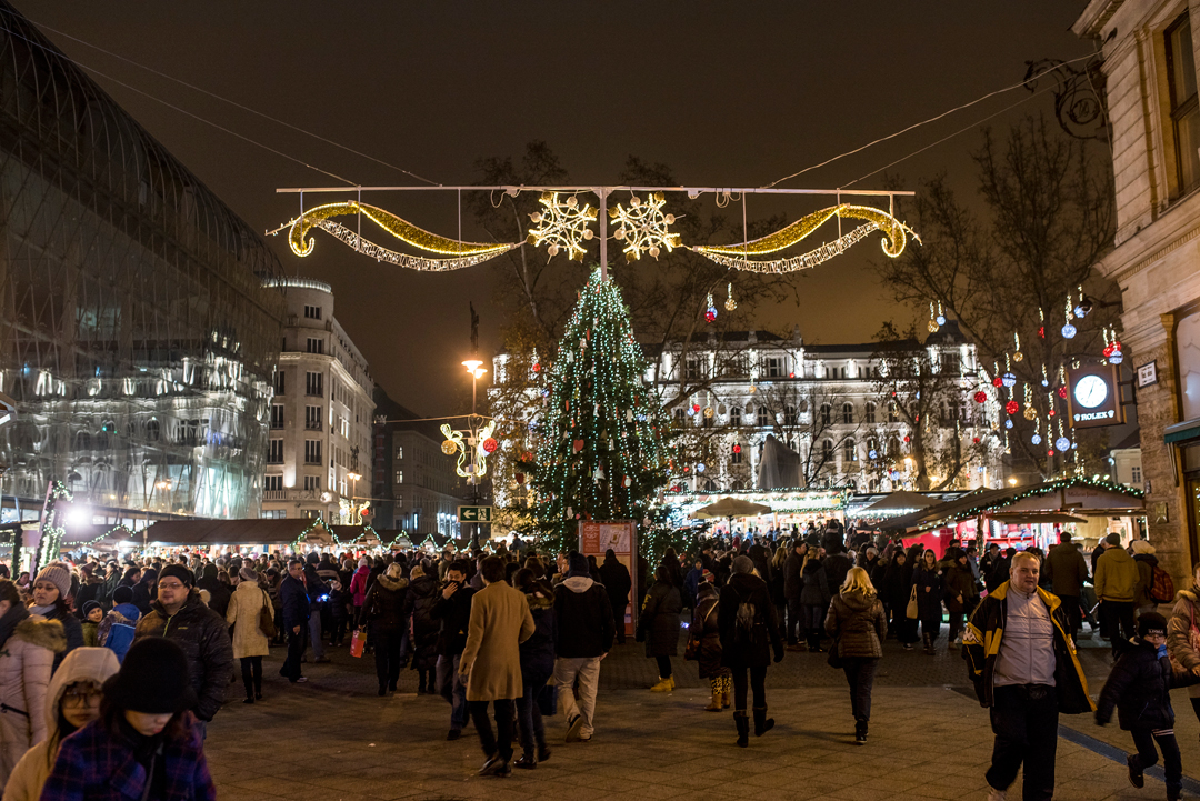 People gather around a large Christmas tree at the Budapest Christmas Fair. 