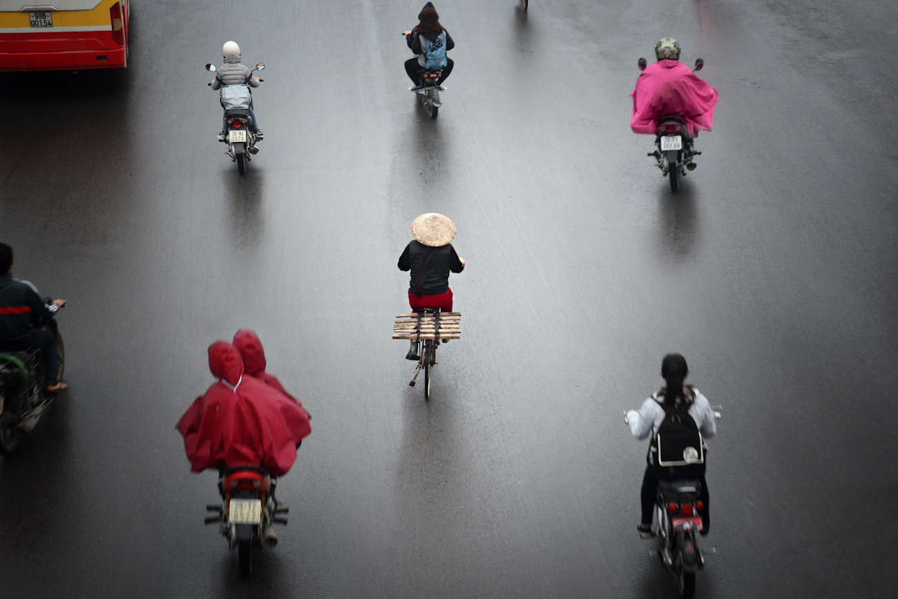 Looking down at motorbike riders on a rainy street in Hanoi