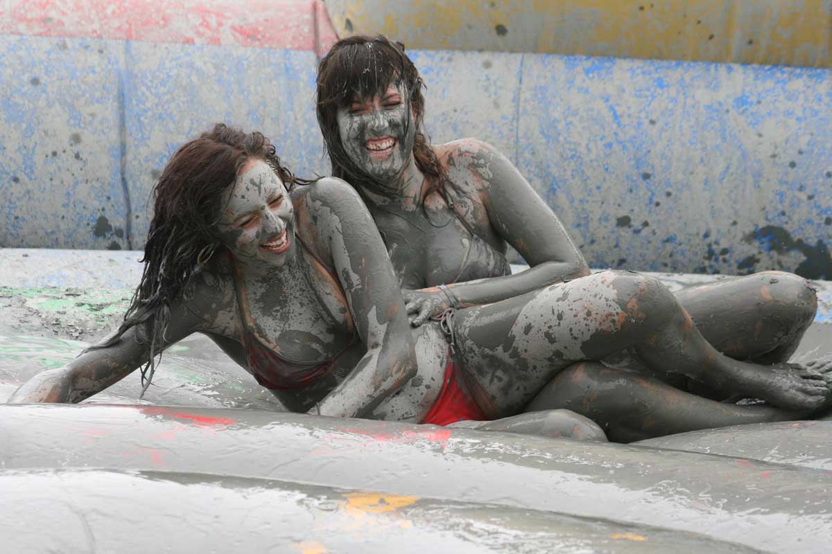Two girls laughing away lying in the mud pool at Boryeoung