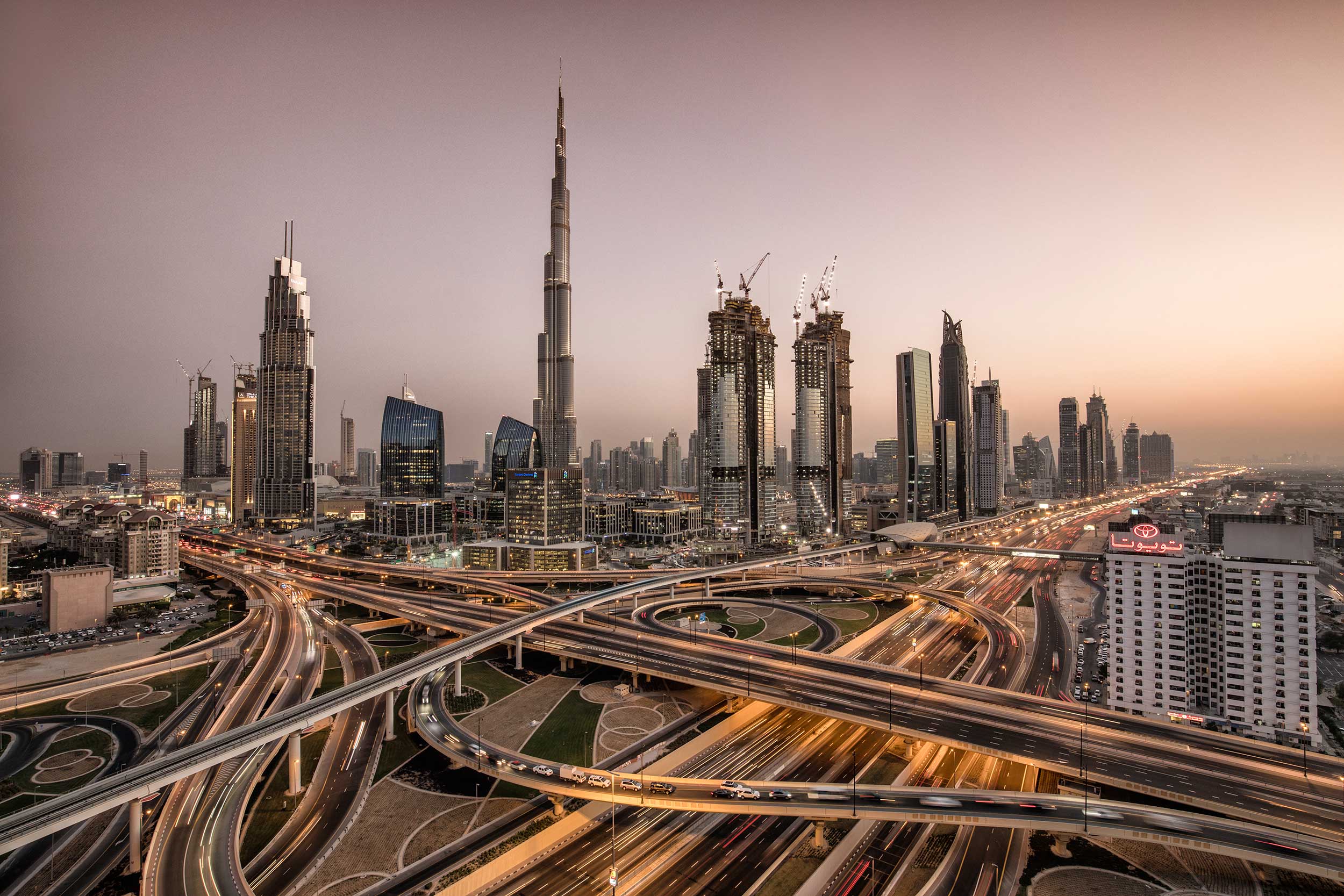 View of the skyscrapers, flyovers and highways of Dubai in the glow of sunset