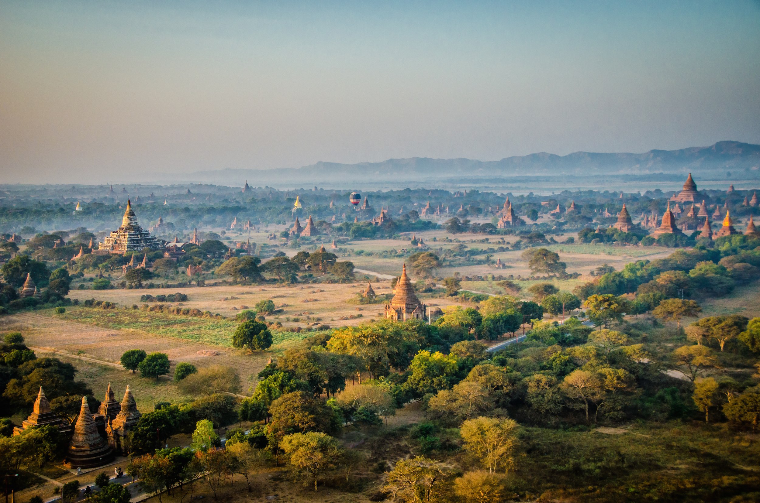 Hundred of temples surrounded by green fields and bushes, at sunrise