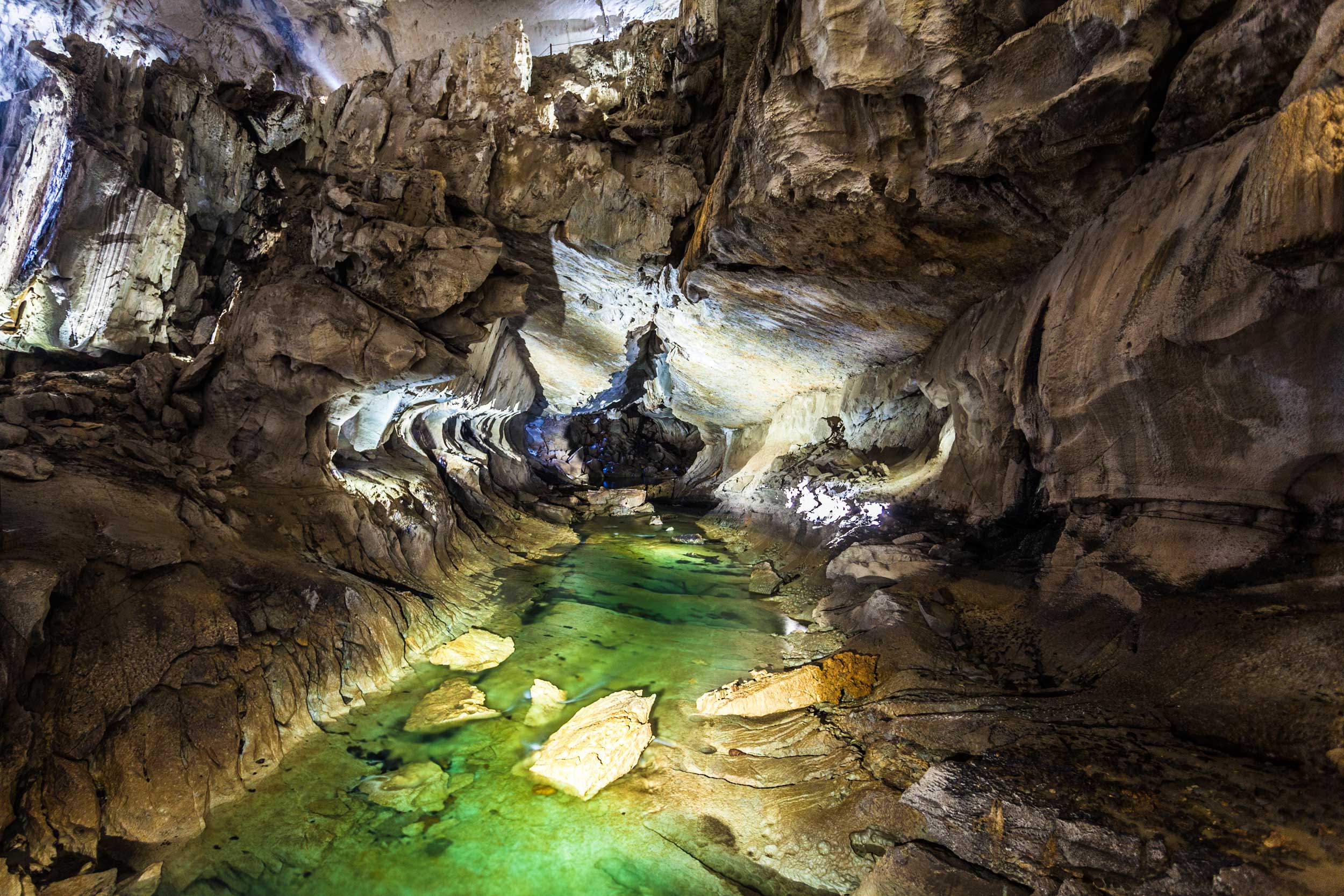 In a cave with a green river running through it in Borneo