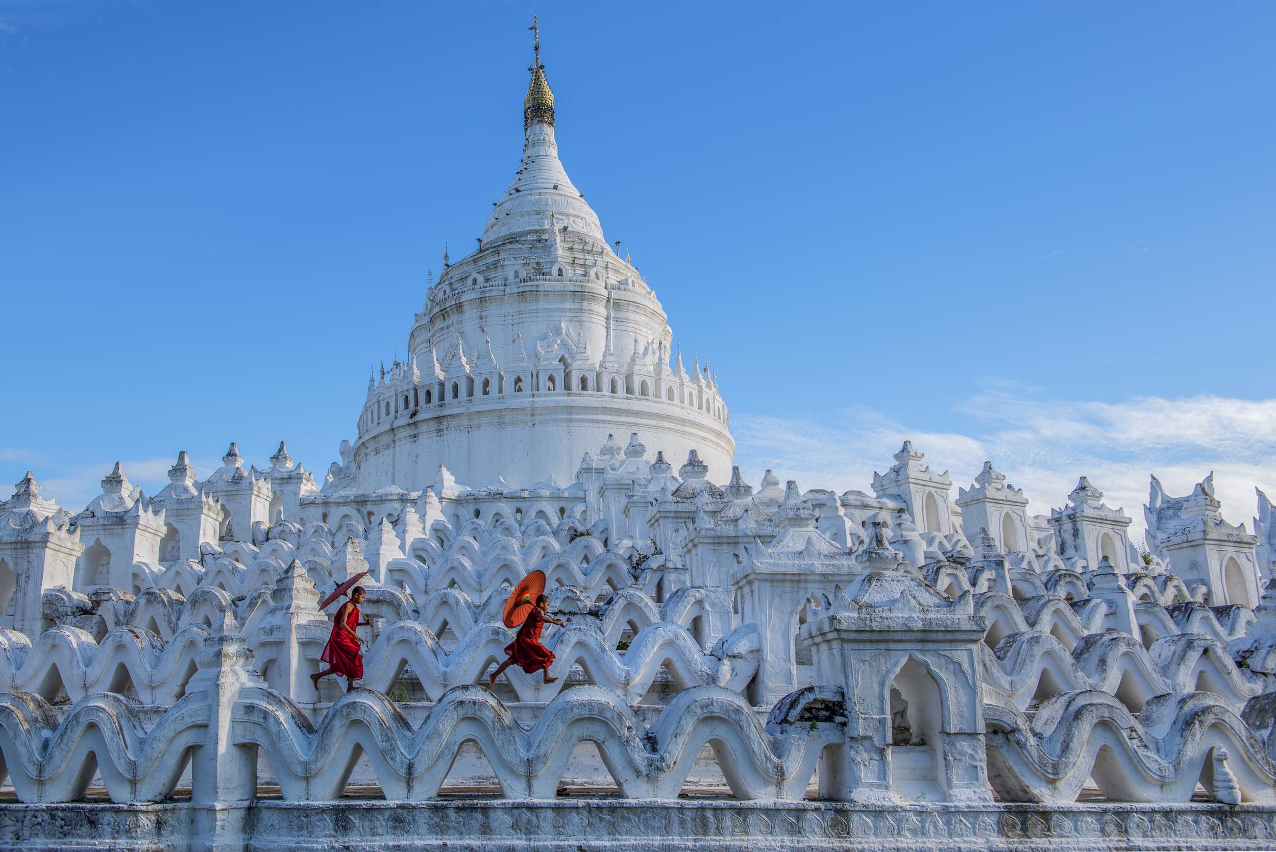 Two boy monks skipping through the stupas of a temple, Myanmar