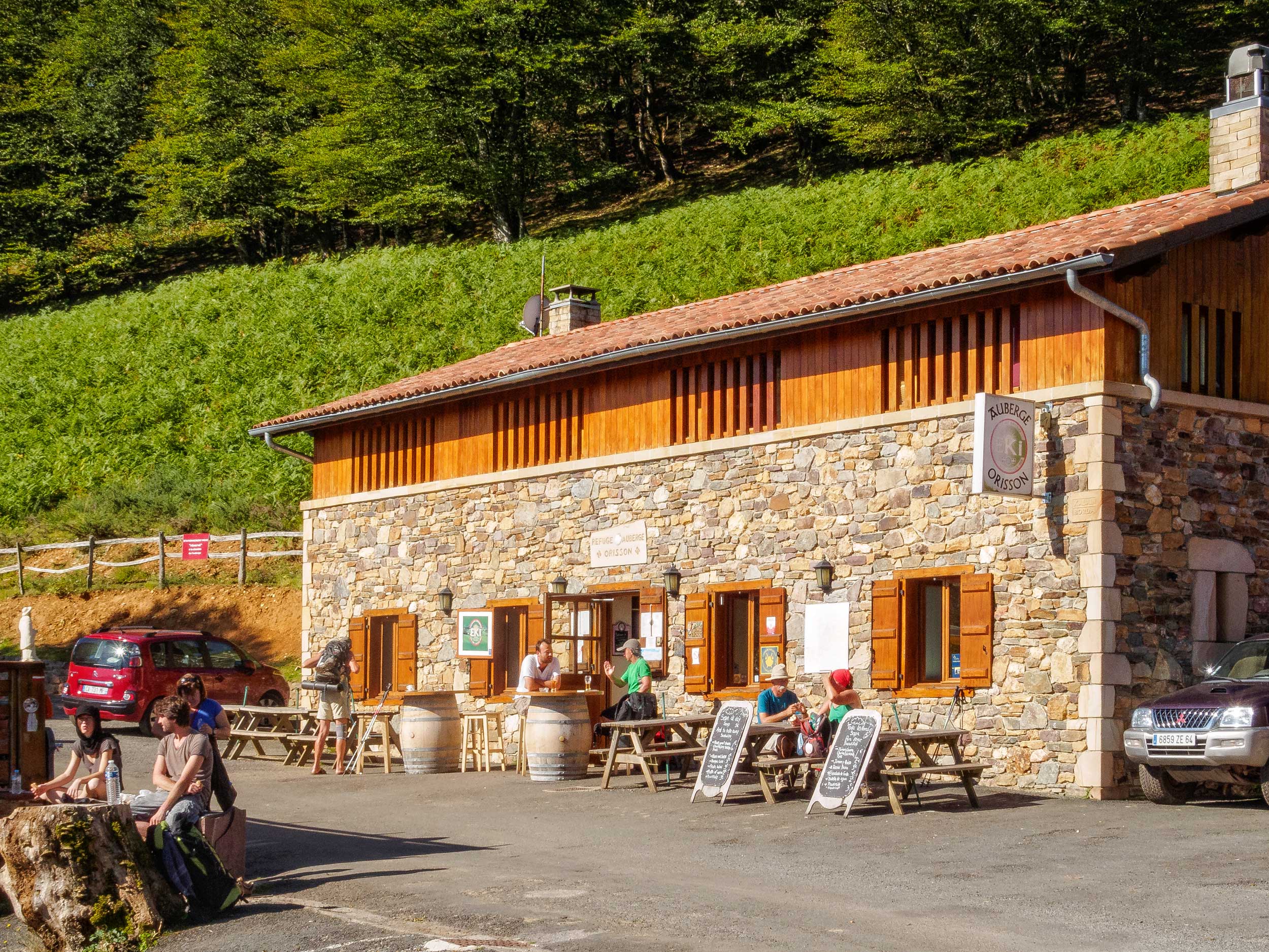 A stone building with people at tables outside, France